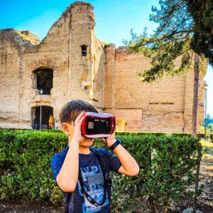 chlapec se dívá do 3D brýlí kde promítají záběry na Terme di Caracalla, Řím