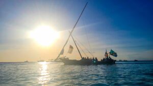 tradiční loď dhow plucí v oceánu při západu slunce na Zanzibaru