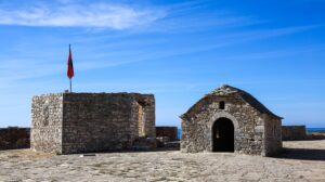 hrad Porto Palermo se vztyčenou albánskou vlajkou