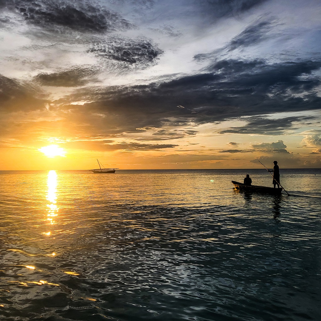 rybářská loď plující v zapadajícím slunci na Zanzibaru