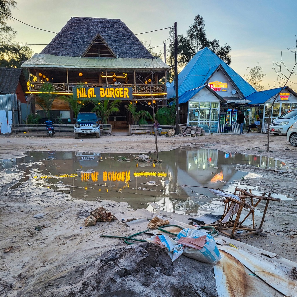 luxusní restaurace na Zanzibaru a velká hromada odpadků a suti v popředí