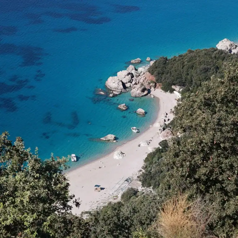 Pláž Krorëz v Albánii z výšky – tyrkysové moře, bílé kameny a oblázkový břeh