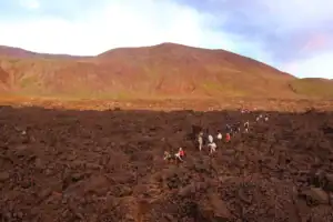 Lidé procházející čerstvým lávovým polem v okolí sopky Sundhnúkur na Islandu