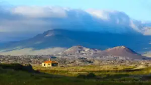 starý domek na Islandu stojící v pusté krajině s výhledem na kráter, hory a lávové pole
