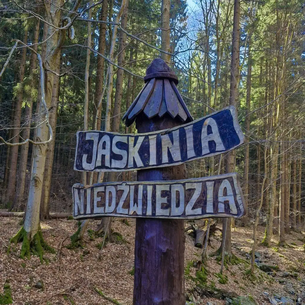 velký dřevěný sloup s npisem "Jaskinia Niedwiedzia" - Medvědí jeskyně
