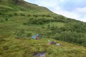 Rodina staví stan v přírodě během přechodu West Highland Way ve Skotsku
